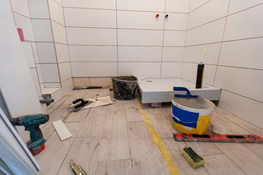 Renovation Services for Marsden Park Homes Bathroom under renovation with new wall tiles, a shower base, tools and a bucket of adhesive